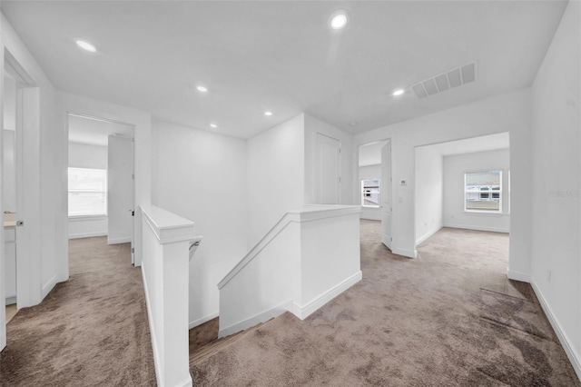 hallway featuring an upstairs landing, carpet floors, baseboards, and recessed lighting