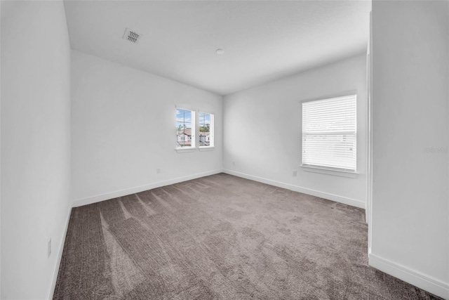 carpeted empty room featuring baseboards
