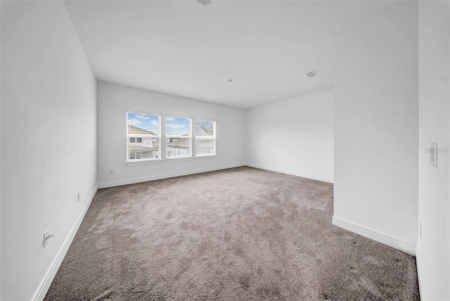 carpeted empty room with baseboards
