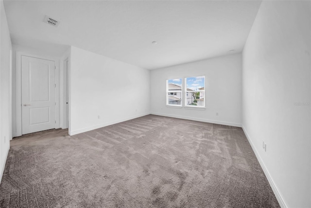 empty room featuring carpet and baseboards
