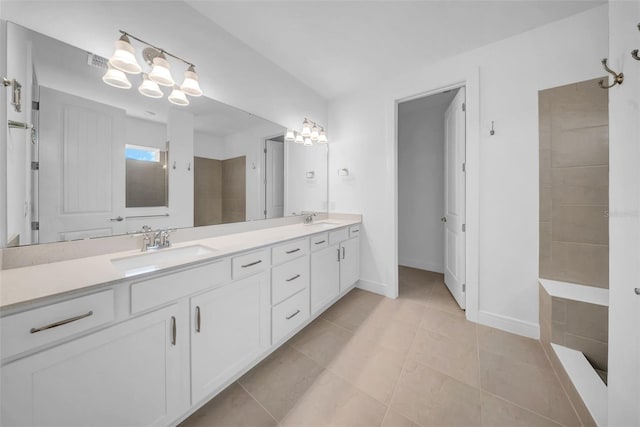 bathroom featuring double vanity, tile patterned flooring, a chandelier, and baseboards