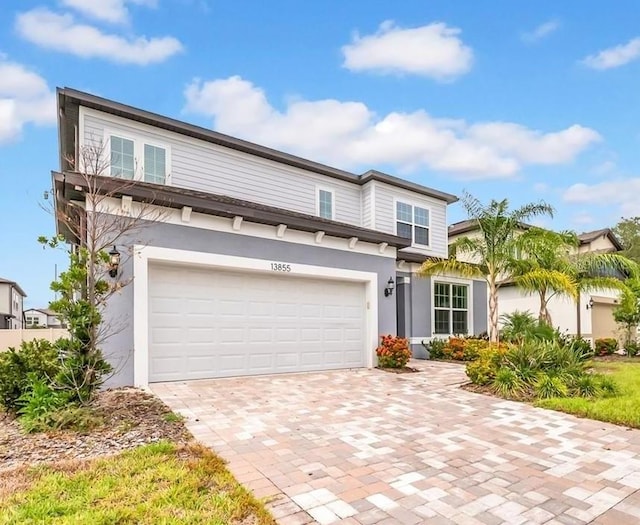 13855 Sharp Hawk Dr, Riverview, FL 33569 - view of front facade featuring a garage, decorative driveway, and stucco siding