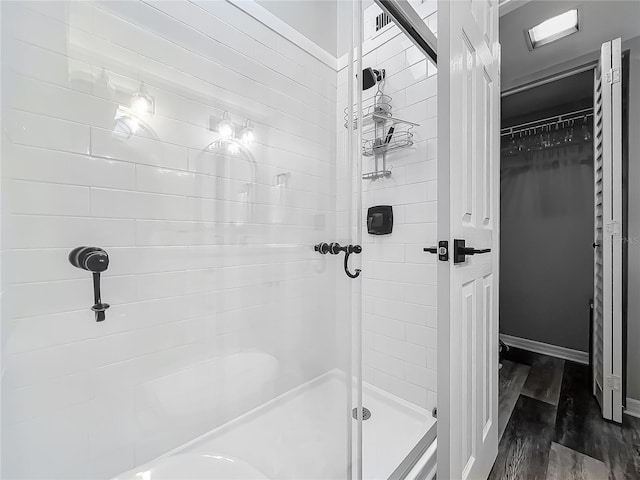 2653 N Seabreeze Pt Unit M-2, Crystal River, FL 34429 - bathroom featuring a shower stall, wood finished floors, and a spacious closet