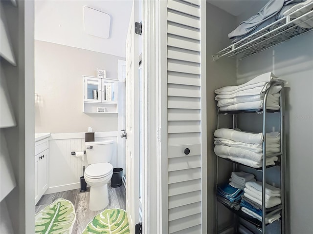 2653 N Seabreeze Pt Unit M-2, Crystal River, FL 34429 - bathroom featuring wood finished floors, wainscoting, toilet, and vanity