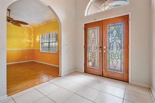 3013 Crest Dr, Clearwater, FL 33759 - tiled entrance foyer with french doors, healthy amount of natural light, arched walkways, baseboards, and crown molding