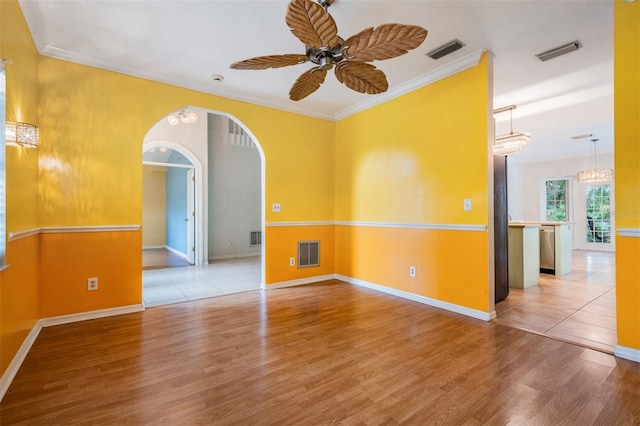3013 Crest Dr, Clearwater, FL 33759 - spare room with ceiling fan, light wood finished floors, arched walkways, baseboards, and crown molding