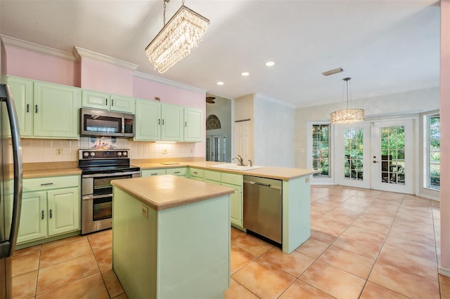 3013 Crest Dr, Clearwater, FL 33759 - kitchen featuring appliances with stainless steel finishes, a chandelier, green cabinetry, a peninsula, and a sink