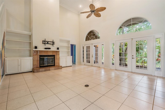 3013 Crest Dr, Clearwater, FL 33759 - unfurnished living room with french doors, a towering ceiling, light tile patterned floors, built in features, and ornamental molding