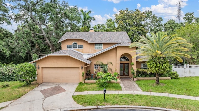 3013 Crest Dr, Clearwater, FL 33759 - view of front of house with stucco siding, french doors, concrete driveway, an attached garage, and a chimney