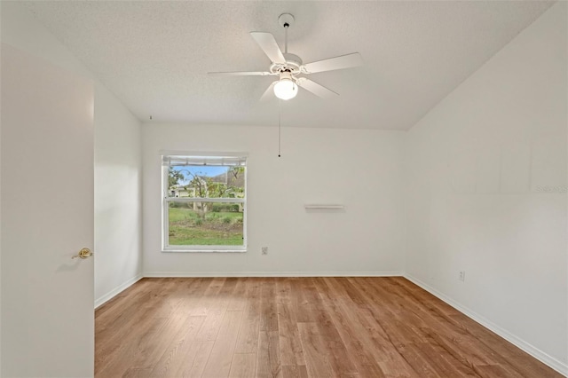 unfurnished room featuring wood finished floors, a ceiling fan, baseboards, and a textured ceiling