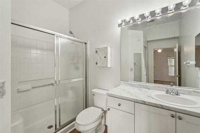full bath with a shower with shower door, toilet, and vanity