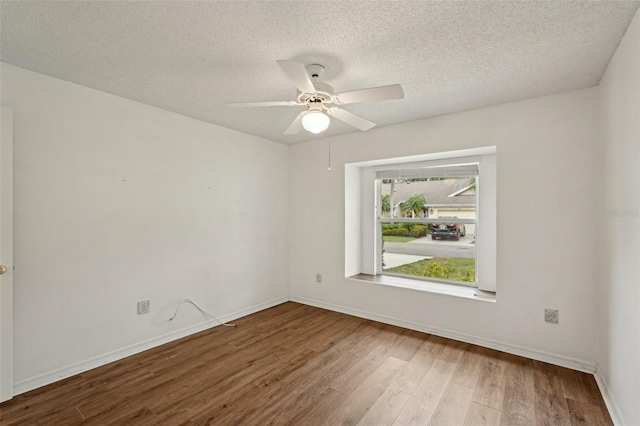 unfurnished room featuring wood finished floors, a textured ceiling, a ceiling fan, and baseboards