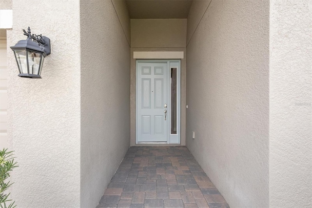 entrance to property featuring stucco siding