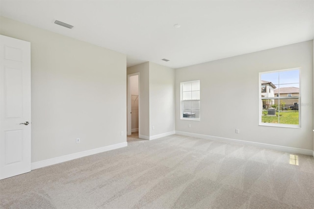 unfurnished room with light carpet and baseboards
