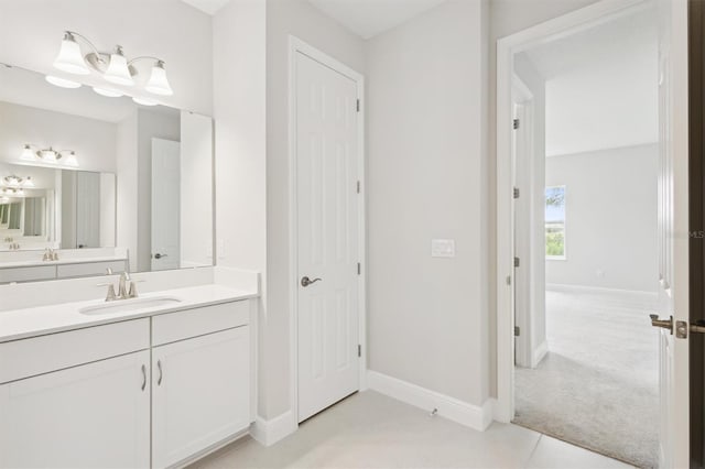 bathroom with baseboards, vanity, and tile patterned flooring