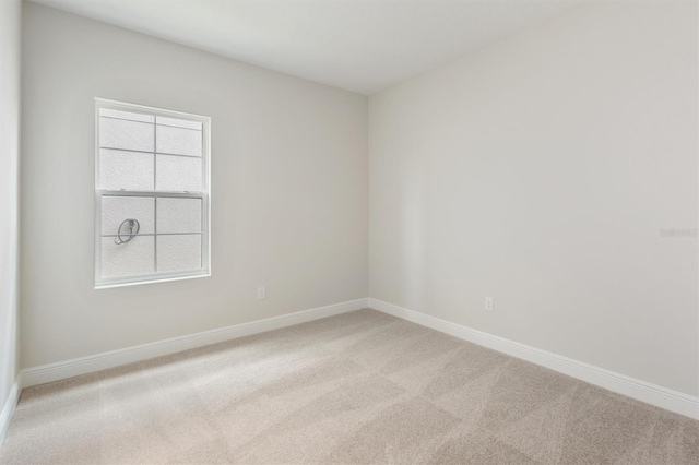 carpeted spare room with baseboards