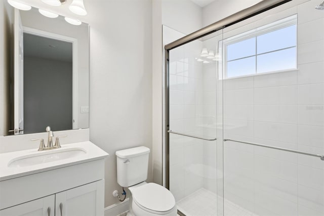 bathroom with a shower stall, toilet, and vanity