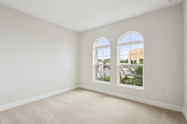 empty room with light carpet and baseboards