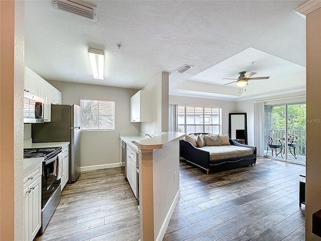 18001 Richmond Place Dr Unit 330, Tampa, FL 33647 - kitchen with stainless steel appliances, wood finished floors, baseboards, light countertops, and a textured ceiling
