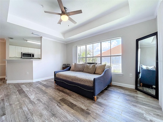 18001 Richmond Place Dr Unit 330, Tampa, FL 33647 - bedroom with a tray ceiling, light wood-style floors, crown molding, baseboards, and a ceiling fan