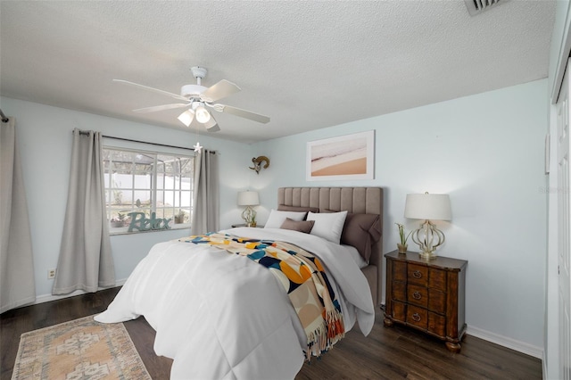 12913 126th Ter, Largo, FL 33774 - bedroom featuring dark wood-type flooring, ceiling fan, a textured ceiling, and baseboards