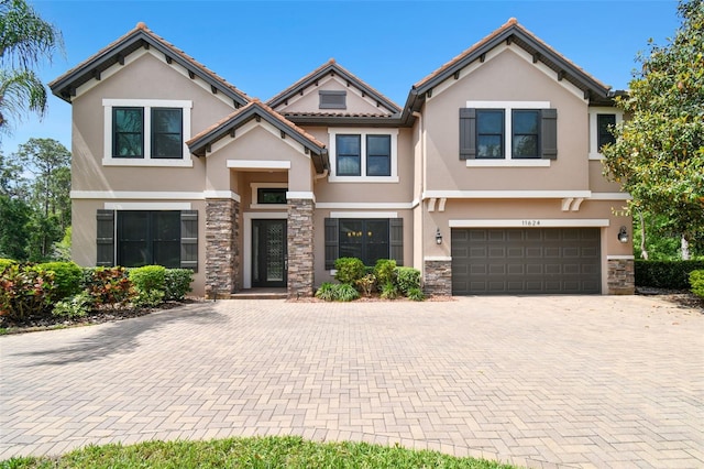 11624 Calf Path Dr, Tampa, FL 33626 - townhome / multi-family property with stucco siding, stone siding, an attached garage, and decorative driveway