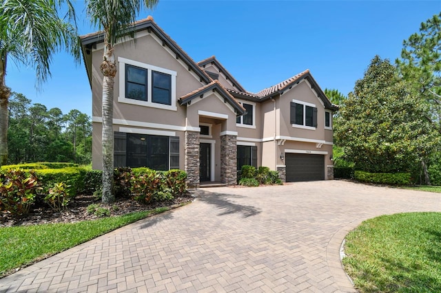 11624 Calf Path Dr, Tampa, FL 33626 - view of front facade with stone siding, stucco siding, an attached garage, and decorative driveway