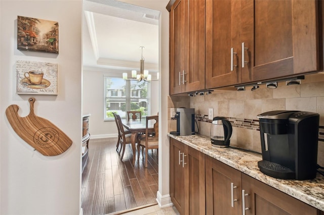 11624 Calf Path Dr, Tampa, FL 33626 - bar area with tasteful backsplash, a raised ceiling, crown molding, baseboards, and a chandelier