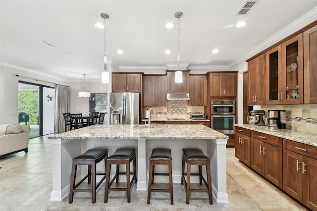 11624 Calf Path Dr, Tampa, FL 33626 - kitchen with appliances with stainless steel finishes, under cabinet range hood, a breakfast bar, a sink, and crown molding