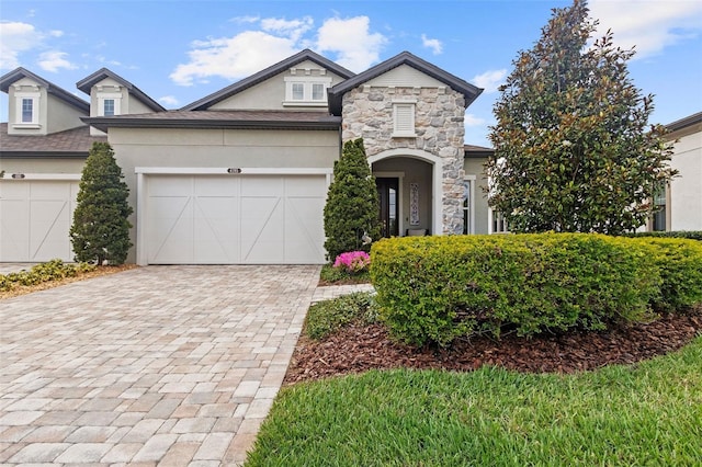 4195 Barletta Ct, Wesley Chapel, FL 33543 - view of front of house featuring stucco siding, decorative driveway, stone siding, and a garage