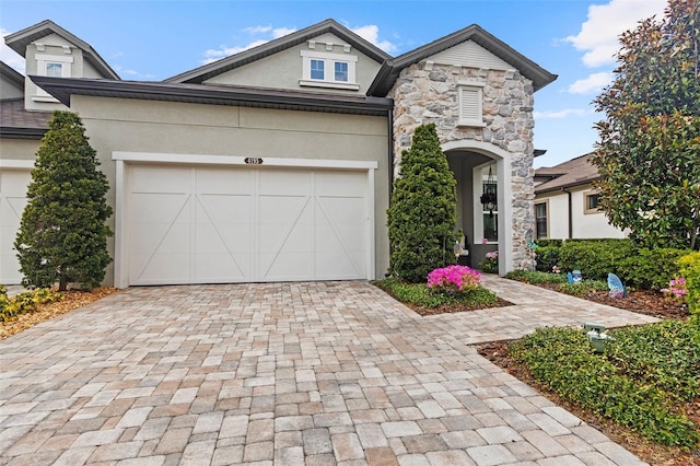 4195 Barletta Ct, Wesley Chapel, FL 33543 - view of front of home featuring decorative driveway, stucco siding, stone siding, and a garage