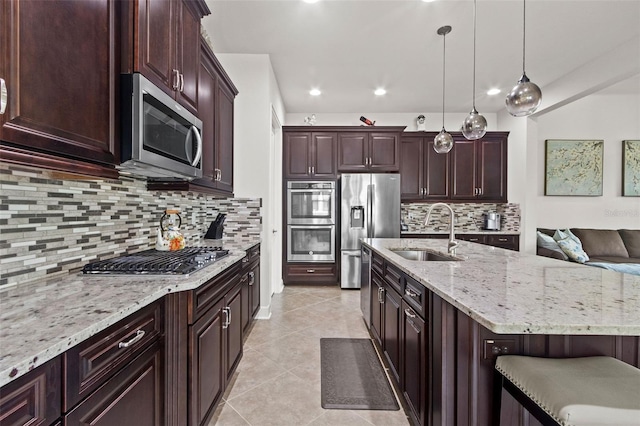 4195 Barletta Ct, Wesley Chapel, FL 33543 - kitchen featuring appliances with stainless steel finishes, tasteful backsplash, light stone countertops, light tile patterned flooring, and decorative light fixtures