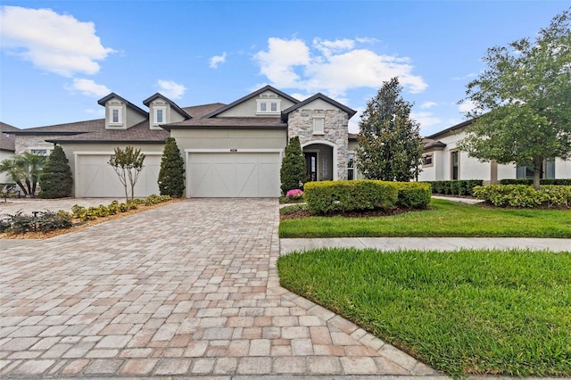 4195 Barletta Ct, Wesley Chapel, FL 33543 - french country inspired facade featuring stone siding, decorative driveway, stucco siding, a garage, and a front lawn