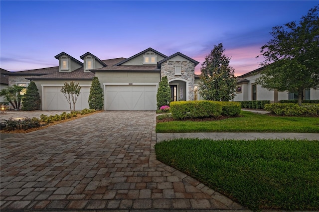 4195 Barletta Ct, Wesley Chapel, FL 33543 - view of front of house featuring decorative driveway, stone siding, an attached garage, and stucco siding