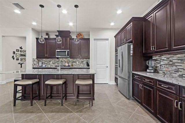 4195 Barletta Ct, Wesley Chapel, FL 33543 - kitchen featuring appliances with stainless steel finishes, tasteful backsplash, a breakfast bar, and recessed lighting