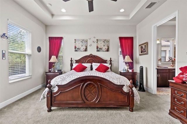 4195 Barletta Ct, Wesley Chapel, FL 33543 - bedroom with a tray ceiling, light carpet, recessed lighting, and connected bathroom