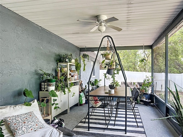 sunroom / solarium featuring ceiling fan and outdoor dining area