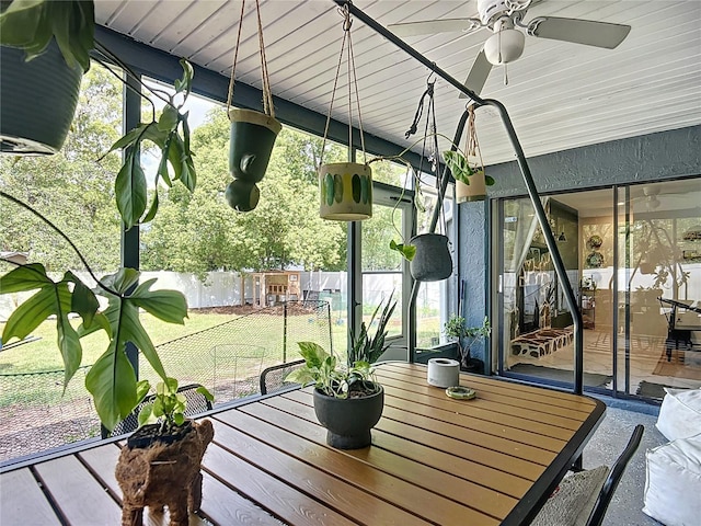 unfurnished sunroom with ceiling fan