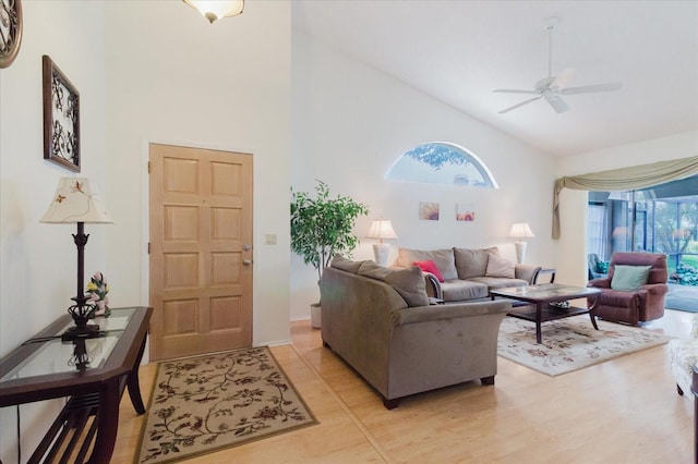 living area with high vaulted ceiling, light wood-style flooring, and ceiling fan