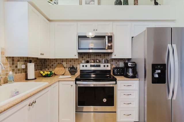 kitchen featuring stainless steel appliances, a sink, white cabinets, and light countertops