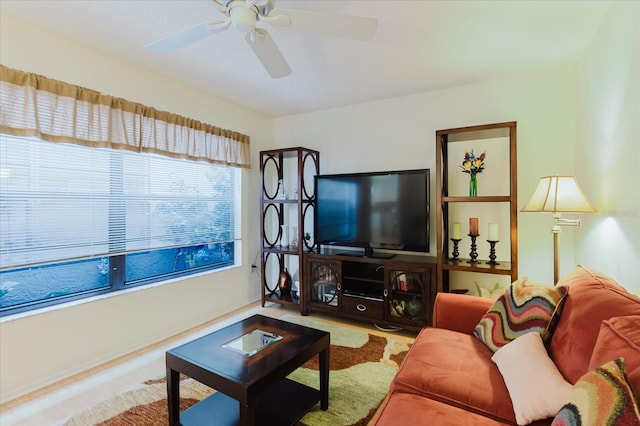 living area featuring a ceiling fan and baseboards