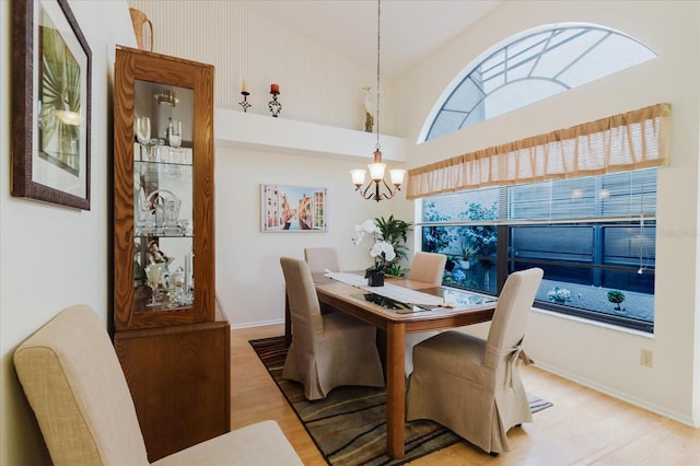 dining area featuring light wood-style flooring, a chandelier, and baseboards