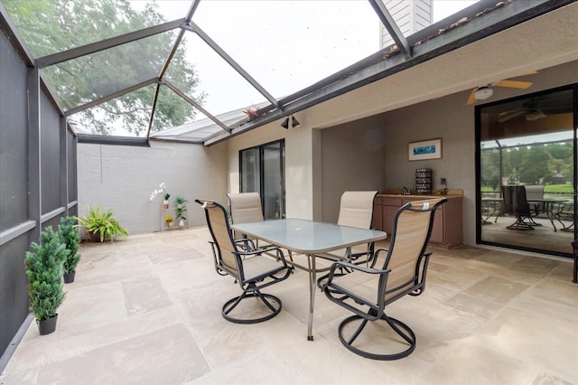 view of patio / terrace with outdoor dining space, a lanai, and a ceiling fan
