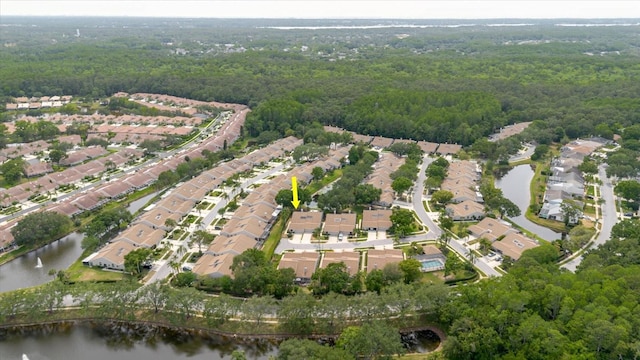 aerial overview of property's location featuring a heavily wooded area, a large body of water, and nearby suburban area