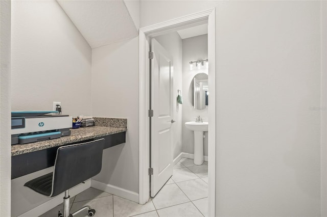 3212 Calvano Dr, Land O Lakes, FL 34639 - home office with light tile patterned floors, built in desk, and baseboards
