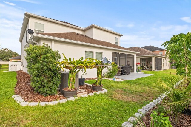 3212 Calvano Dr, Land O Lakes, FL 34639 - rear view of house featuring a sunroom, a yard, stucco siding, and central AC