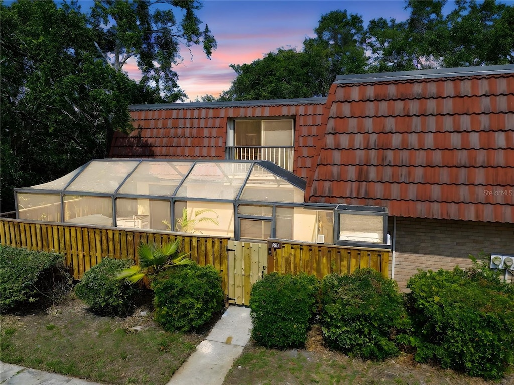 706 1st Ct, Palm Harbor, FL 34684 - view of front of home with a tiled roof, brick siding, an exterior structure, and mansard roof