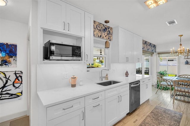 1769 Brookside Blvd, Largo, FL 33770 - kitchen featuring appliances with stainless steel finishes, a sink, white cabinetry, and a chandelier