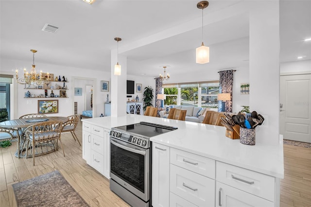 1769 Brookside Blvd, Largo, FL 33770 - kitchen featuring a chandelier, stainless steel range with electric cooktop, open floor plan, and white cabinetry