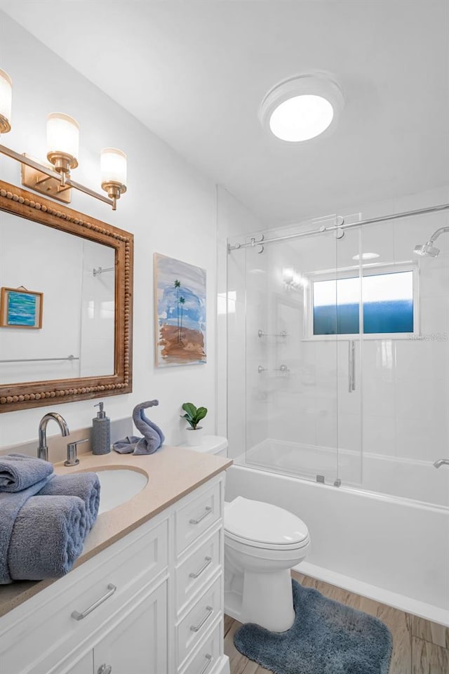 1769 Brookside Blvd, Largo, FL 33770 - bathroom featuring vanity, combined bath / shower with glass door, toilet, and wood finished floors